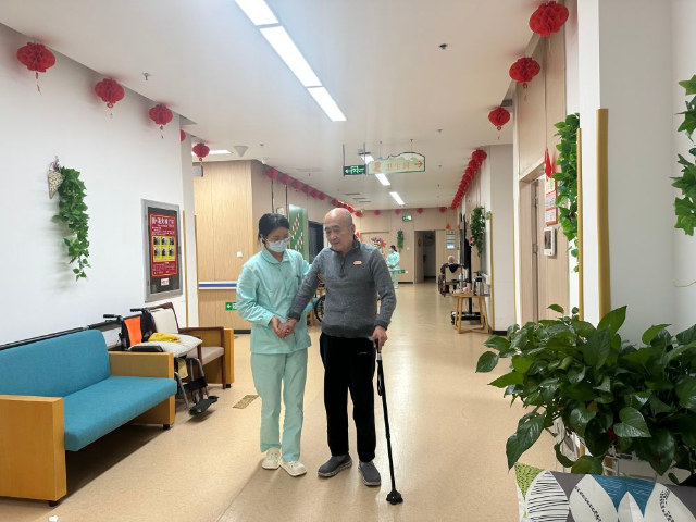 1715569007758405.jpg 護理員喬瑞霞正在輔助入住中心的全托老人行走.jpg